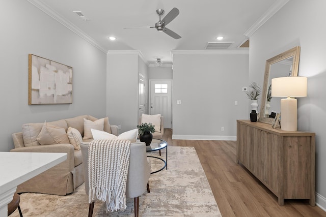 living area featuring light wood-type flooring, crown molding, a ceiling fan, and visible vents