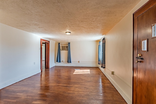 empty room featuring dark hardwood / wood-style floors and a textured ceiling