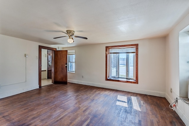 unfurnished room featuring a textured ceiling, ceiling fan, plenty of natural light, and dark hardwood / wood-style floors