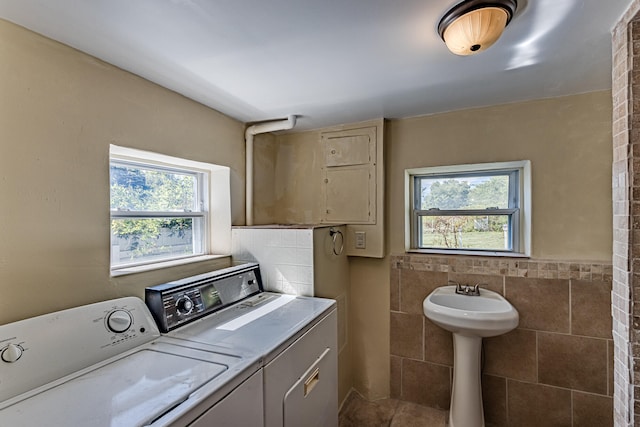 washroom with washing machine and dryer and tile walls