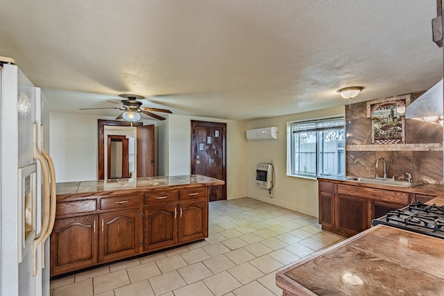 kitchen with ceiling fan, white fridge with ice dispenser, a wall mounted air conditioner, heating unit, and tile countertops