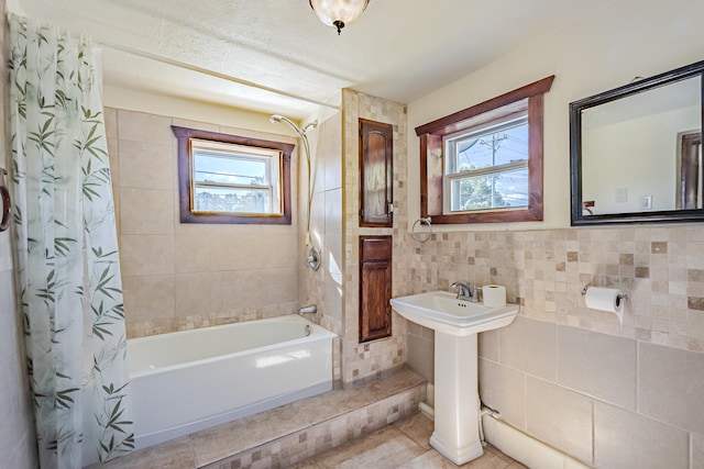 bathroom featuring tile patterned flooring, plenty of natural light, tile walls, and shower / tub combo