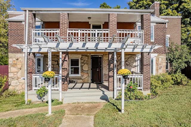 view of front of home with a front yard, a porch, a pergola, and a balcony