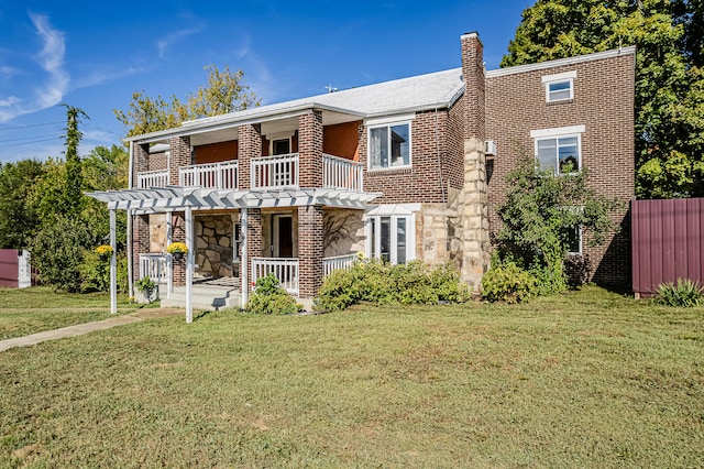 view of front facade featuring a balcony, covered porch, and a front yard