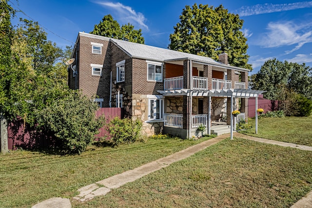 front of property featuring a porch, a balcony, and a front yard