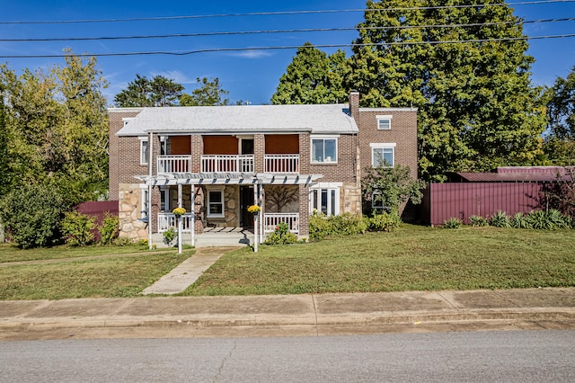 view of front facade with a balcony and a front lawn