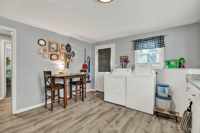315 Gilliland Rd SE, Cleveland, TN 37311 - laundry room featuring separate washer and dryer, light wood-type flooring, and cabinet space
