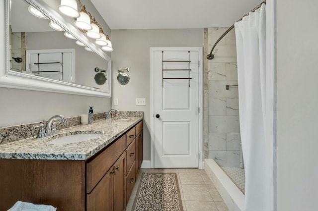 bathroom featuring tile patterned flooring, a sink, double vanity, and tiled shower