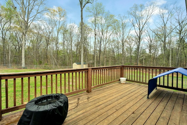deck featuring a lawn, an outbuilding, fence, and a shed