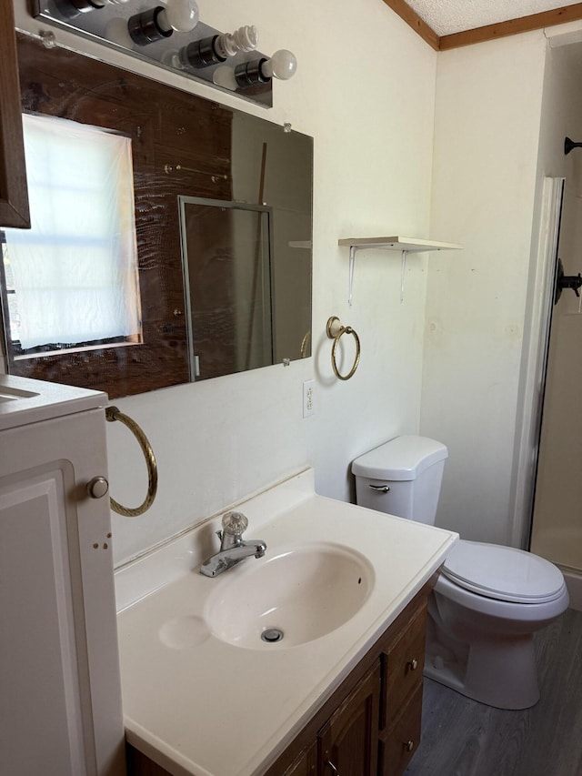 full bath with vanity, toilet, a shower stall, and wood finished floors