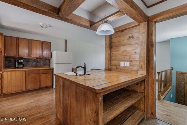 kitchen with sink, white refrigerator, decorative backsplash, kitchen peninsula, and light wood-type flooring