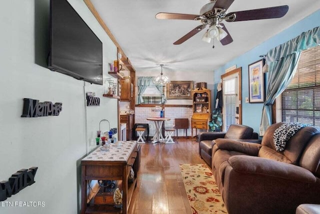 living room with wood-type flooring, ceiling fan with notable chandelier, and a wealth of natural light