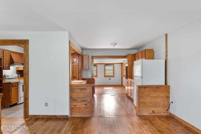 kitchen with white appliances and light hardwood / wood-style flooring