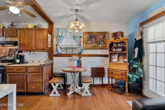 kitchen with ceiling fan, light wood-type flooring, and decorative light fixtures