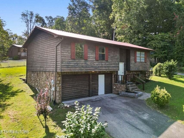 bi-level home with a garage and a front lawn