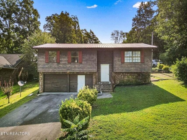 split foyer home featuring a garage and a front yard