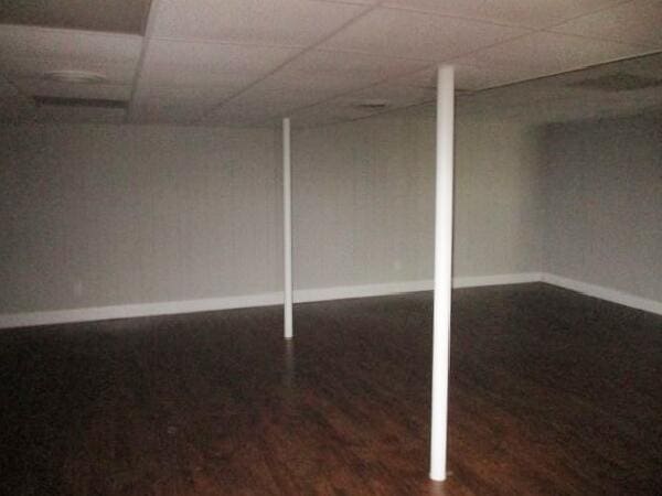 finished basement featuring wood finished floors, baseboards, and a paneled ceiling