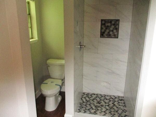 full bathroom featuring toilet and a shower stall