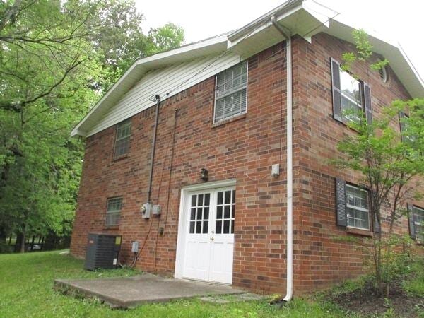 view of home's exterior with brick siding and cooling unit
