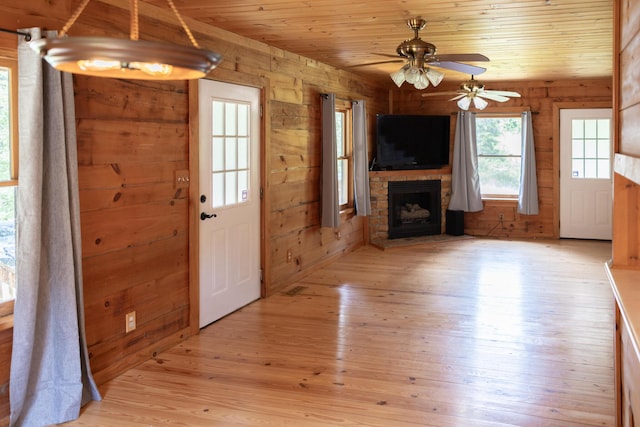 11249 Possum Trail Rd, Harrison, TN 37341 - unfurnished living room with wooden walls, light wood-style floors, a fireplace, wood ceiling, and a ceiling fan