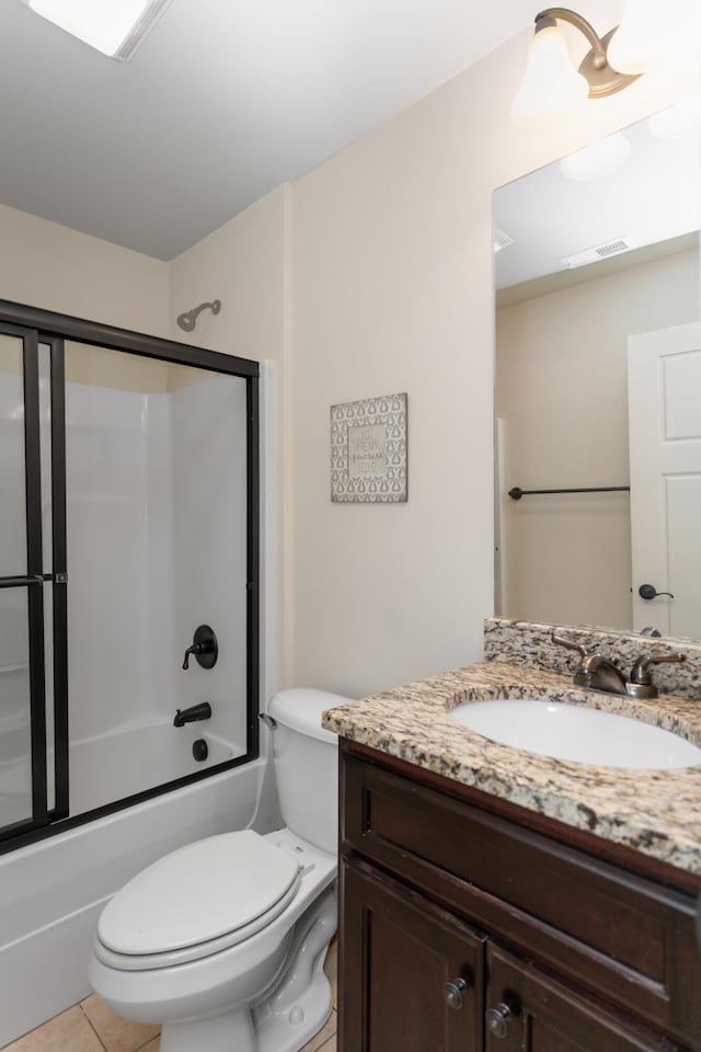 full bathroom featuring toilet, tile patterned floors, vanity, and bath / shower combo with glass door