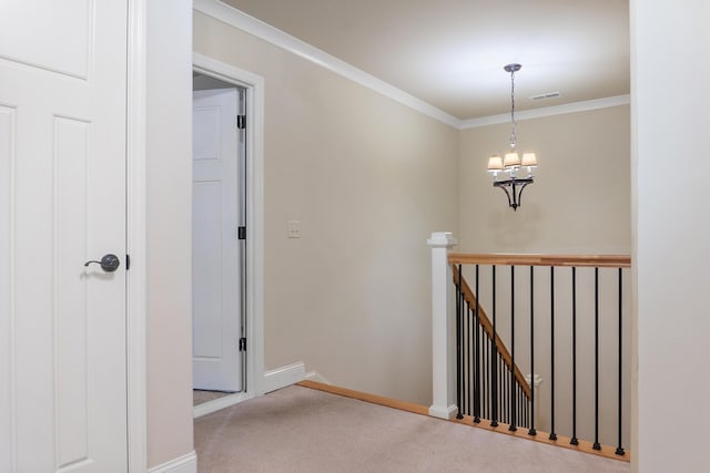 hallway with crown molding, carpet, and a chandelier