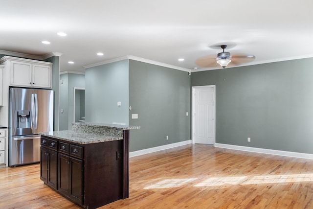 kitchen with stainless steel refrigerator with ice dispenser, dark brown cabinets, light wood-type flooring, ornamental molding, and ceiling fan