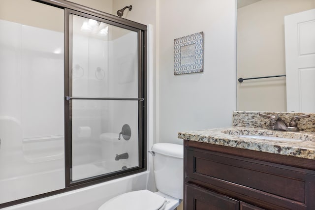 full bathroom featuring vanity, enclosed tub / shower combo, and toilet