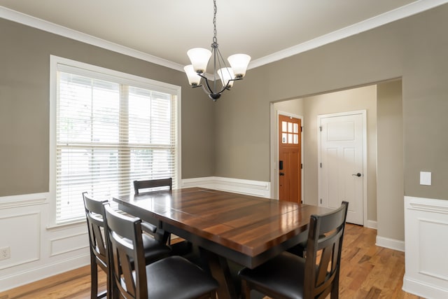 dining area featuring an inviting chandelier, a healthy amount of sunlight, crown molding, and light hardwood / wood-style flooring