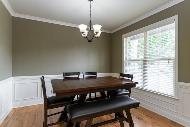 dining room featuring crown molding, plenty of natural light, a notable chandelier, and light hardwood / wood-style flooring