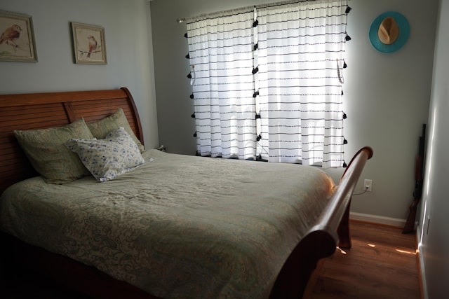 bedroom featuring wood finished floors and baseboards