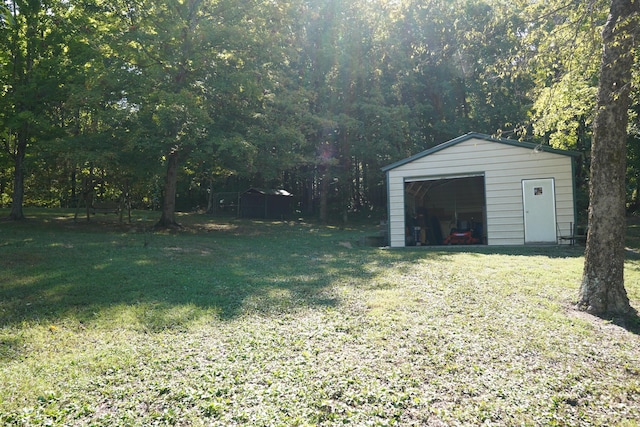 view of yard featuring an outbuilding, driveway, and a detached garage