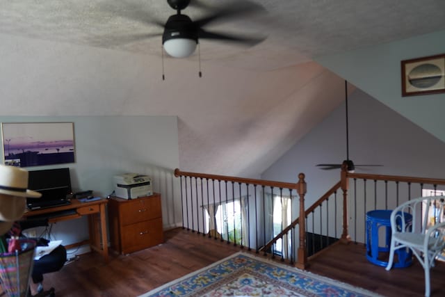 office featuring vaulted ceiling, wood finished floors, and a textured ceiling