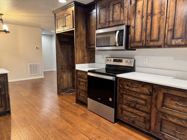 140 Croft Chapel Rd, Turtletown, TN 37391 - kitchen featuring appliances with stainless steel finishes, dark wood finished floors, light countertops, dark brown cabinetry, and recessed lighting