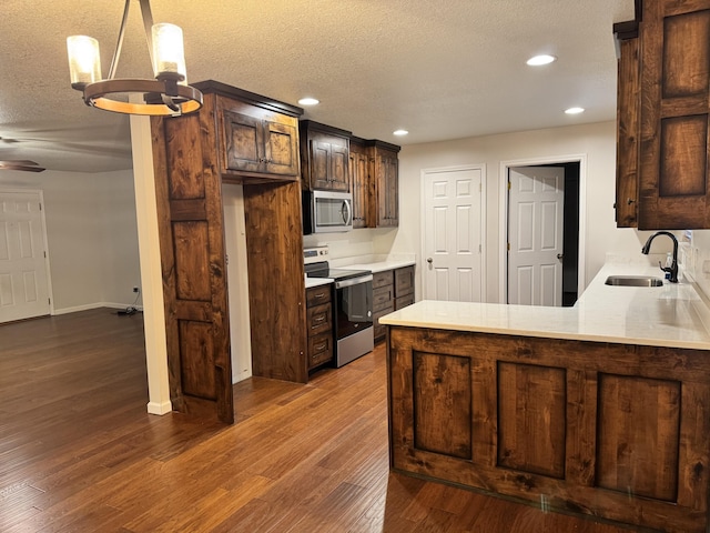 140 Croft Chapel Rd, Turtletown, TN 37391 - kitchen with stainless steel appliances, a sink, a textured ceiling, light countertops, and dark wood-type flooring