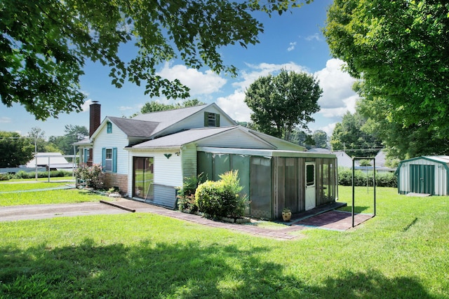 view of front facade featuring a front lawn and a storage shed