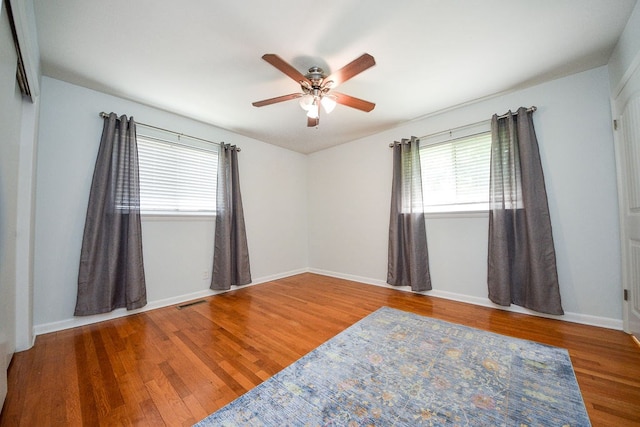 unfurnished room with hardwood / wood-style flooring and ceiling fan