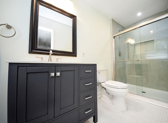 bathroom featuring tile patterned floors, vanity, toilet, and a shower with door