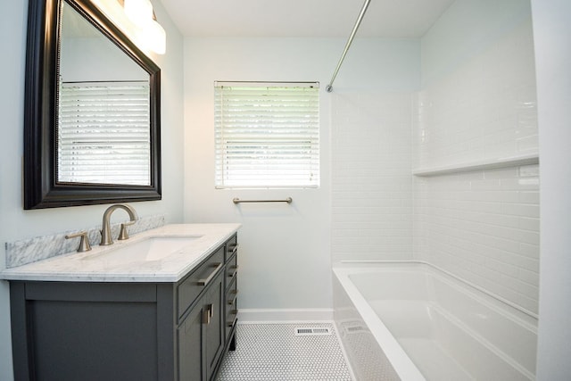 bathroom featuring tile patterned floors, vanity, and tiled shower / bath