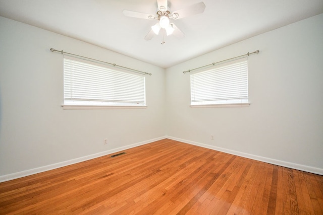 spare room with plenty of natural light, light hardwood / wood-style floors, and ceiling fan