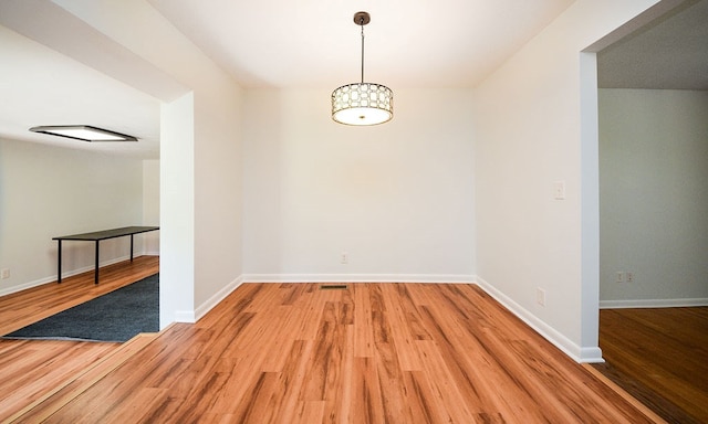 unfurnished dining area featuring wood-type flooring