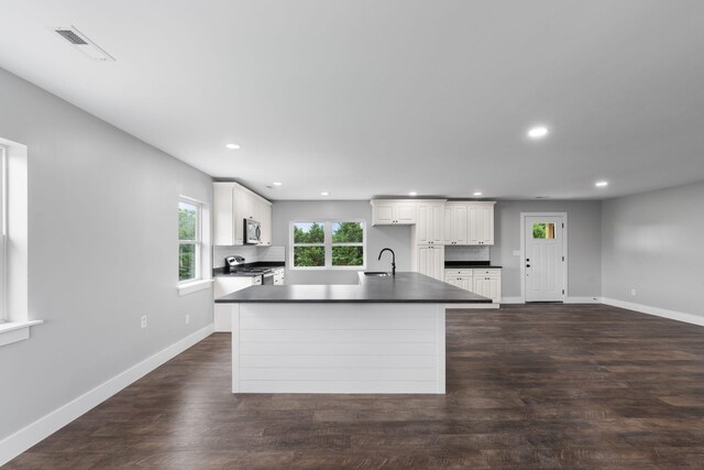 2517 No Pone Rd NW, Georgetown, TN 37336 - kitchen with dark countertops, appliances with stainless steel finishes, recessed lighting, white cabinets, and a center island with sink