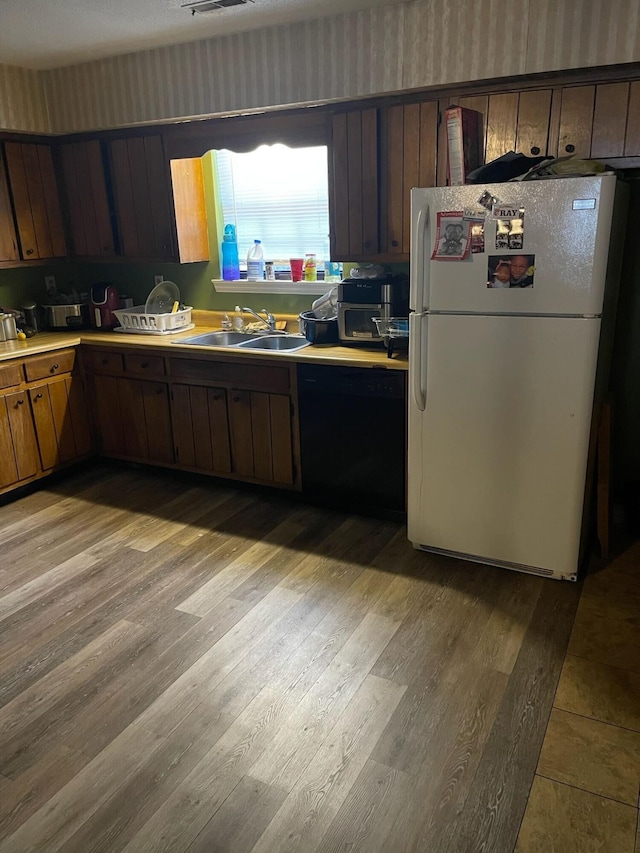 1640 Thrasher Pike, Hixson, TN 37343 - kitchen featuring freestanding refrigerator, black dishwasher, a sink, light wood finished floors, and light countertops