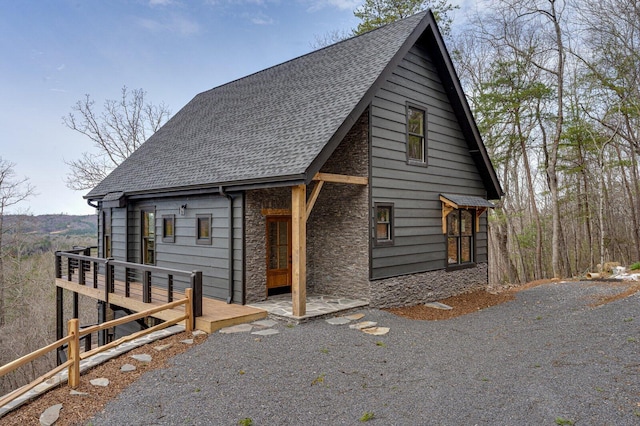 chalet / cabin with stone siding and roof with shingles