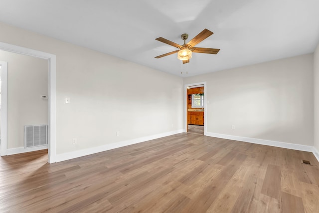 spare room with light wood-type flooring and ceiling fan