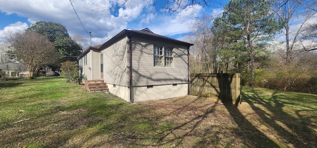 view of side of home featuring crawl space, a yard, and fence