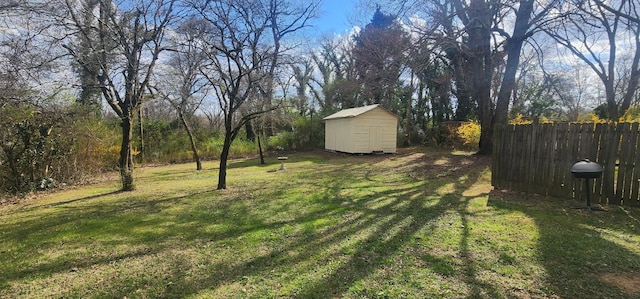 view of yard with an outbuilding, a storage unit, and fence