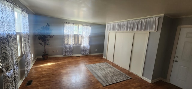 unfurnished bedroom with visible vents, wood finished floors, and crown molding