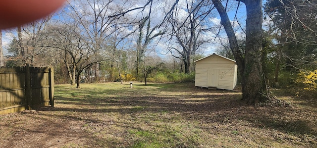 view of yard with an outbuilding, a storage shed, and fence