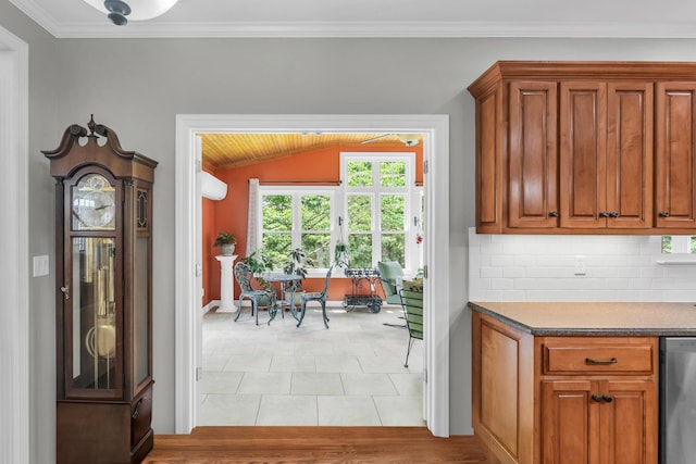 1028 Ivy Manor Ct, Hixson, TN 37343 - kitchen featuring stainless steel dishwasher, brown cabinets, decorative backsplash, vaulted ceiling, and crown molding